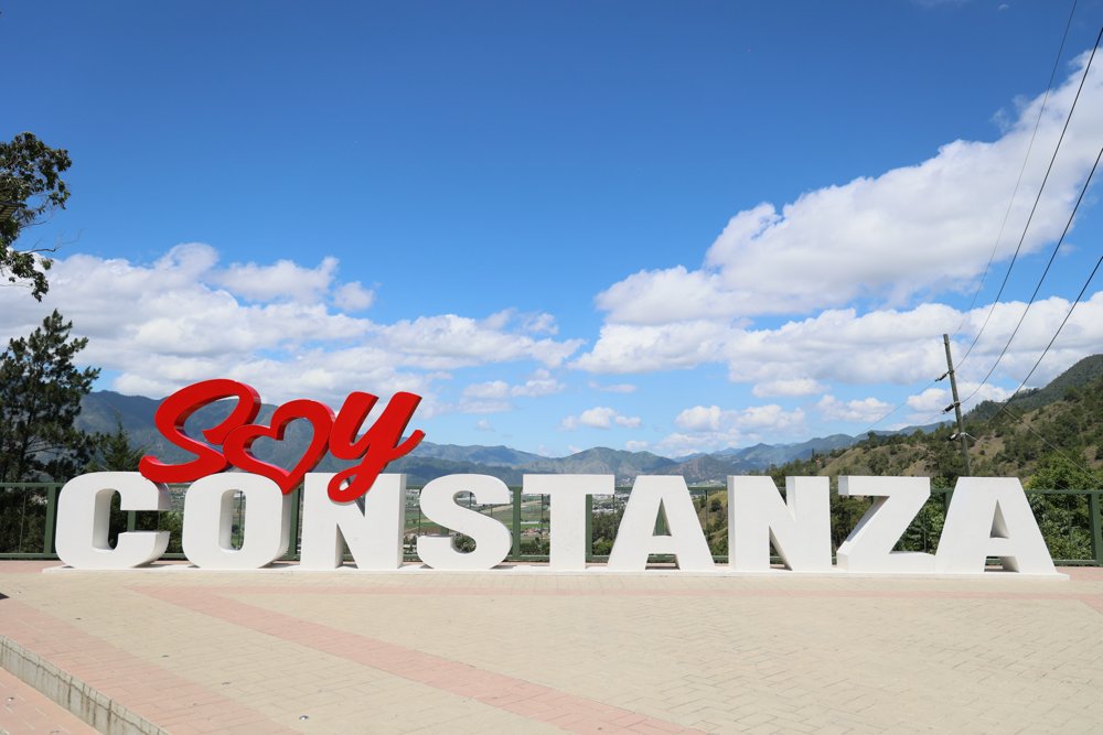 Letrero Soy Constanza, con las montañas de Constanza, República Dominicana de fondo